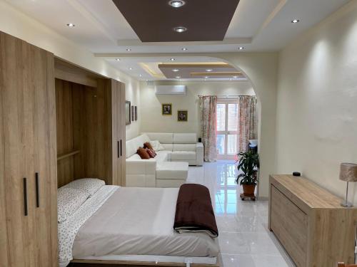 Un dormitorio con una cama y una sala de estar. en Sunrise Apt near beach SmartTV & Netflix, en Birżebbuġa