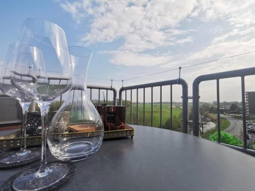 two wine glasses sitting on a table on a balcony at Sonnendeck Nordsee in Horumersiel
