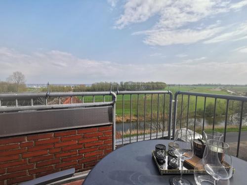 a table with wine glasses on top of a balcony at Sonnendeck Nordsee in Horumersiel