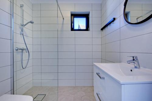 biała łazienka z umywalką i prysznicem w obiekcie Letnisko we Władysławowie