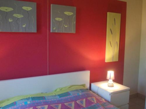 een slaapkamer met rode muren en een bed met een lamp bij Foyti in Dinant