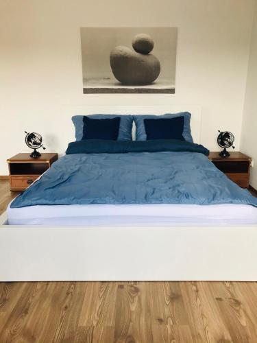 1 dormitorio con 1 cama grande con edredón azul en Apartament Marina Mazury, en Węgorzewo