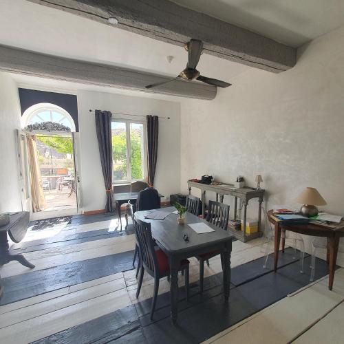 un salon avec une table et des chaises et une fenêtre dans l'établissement Maison Capucine, à Mèze