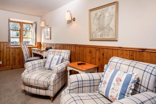 a living room with two chairs and a table at Hotel Eilean Iarmain in Isleornsay
