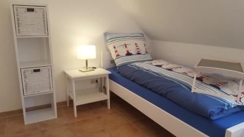 małą sypialnię z łóżkiem i szafką nocną w obiekcie Trekvogels Hörn w mieście Dornum