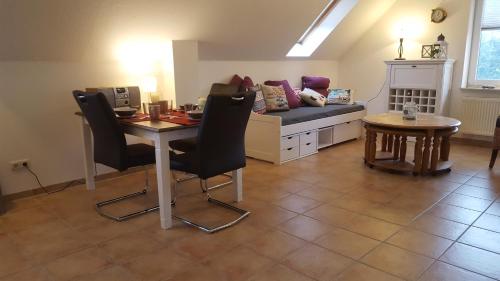 a living room with a table and a couch at Trekvogels Hörn in Dornum