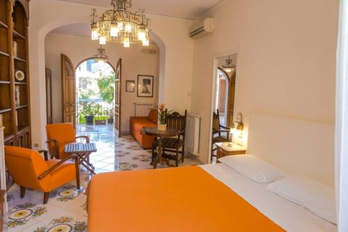 a bedroom with an orange bed and a living room at DON VALERIO SORRENTO in Sorrento