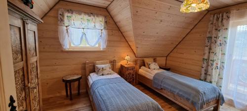 1 Schlafzimmer mit 2 Betten in einem Blockhaus in der Unterkunft Góralski Dom z pięknymi widokami na góry in Sosnowka