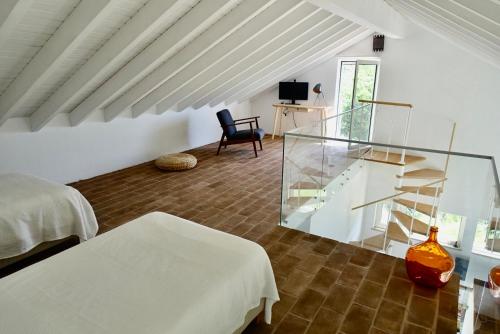 um quarto branco com uma escada de vidro e uma cama em Casa da Esteva em São Miguel