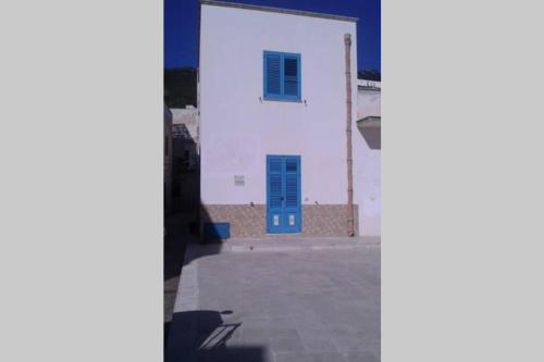 uma vista para um edifício branco com uma porta azul em Vivi Marettimo em Marettimo