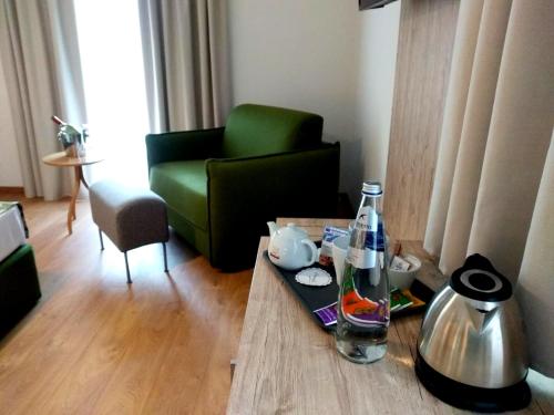 sala de estar con sofá verde y mesa en Hotel Kronplatzer Hof, en Rasun di Sopra