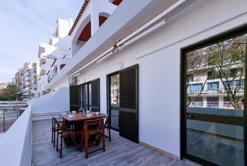 a wooden table on the balcony of a building at Albufeira Old Town T3 with Balcony in Albufeira