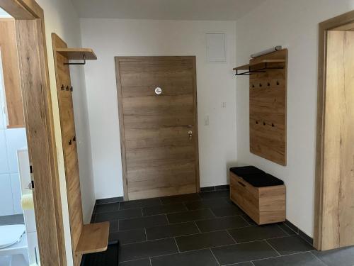 a bathroom with two wooden doors and a tile floor at Ferienwohnung „Gmünder Hof“ in Gmünd