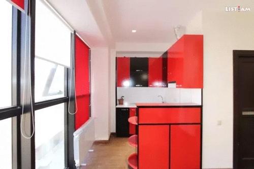 a kitchen with red cabinets and a red counter top at City Central Apartment in Yerevan