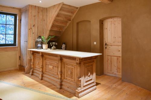 a kitchen with a wooden island in the middle of a room at Naturhof-Papiermühle 2 Bett-Zimmer Rosenrot in Bollberg