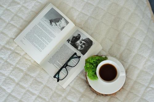 a book and a plate with a cup of coffee and a doughnut at łOWCA PIENIN in Szczawnica