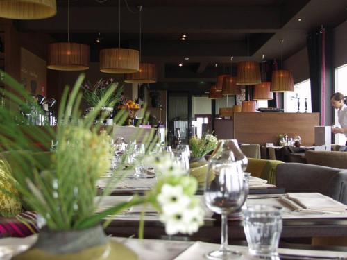 a dining room with tables with wine glasses on them at Hotel Lands End in Den Helder