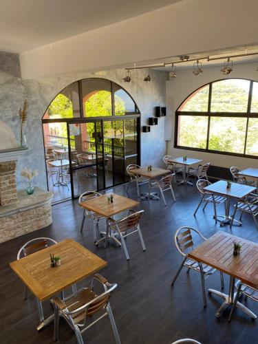 um restaurante com mesas, cadeiras e janelas em U Sant'Agnellu em Rogliano