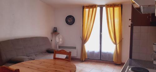 a living room with a couch and a table and a clock at Loc Alp Verdon in Riez