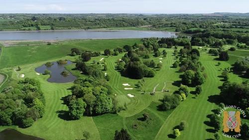 an aerial view of a golf course with a lake at Waterford Castle Hotel Lodges in Waterford