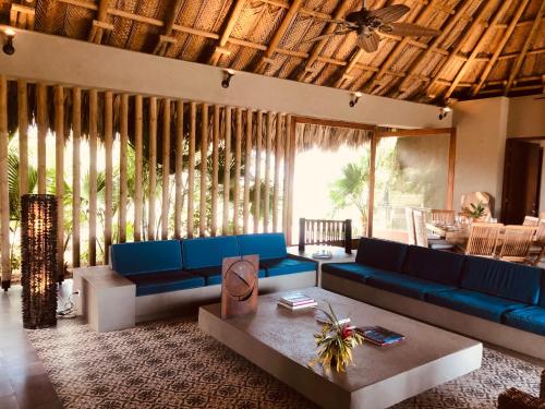 ein Wohnzimmer mit blauen Sofas und einem Tisch in der Unterkunft Territorio Magico Dibulla in Dibulla