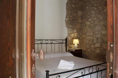 1 dormitorio con 1 cama en una pared de piedra en Dimora Krifò, en Martano