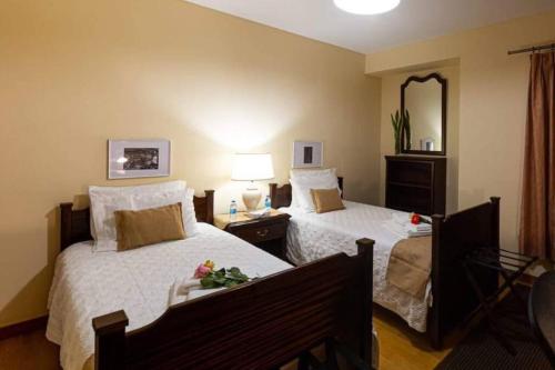 Pokój hotelowy z 2 łóżkami i lustrem w obiekcie S.George Apartment w mieście Ponta Delgada