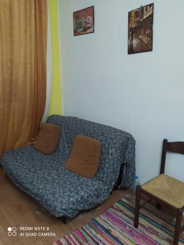 un sofá en una sala de estar con una silla en My Athens Home, en Atenas