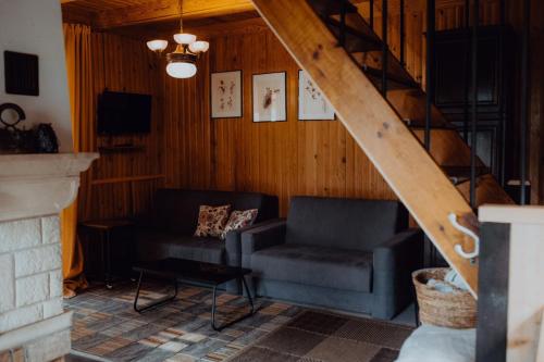 uma sala de estar com um sofá e uma escada em Dom w Puszczy em Supraśl