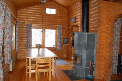 comedor con estufa de leña en una cabaña de madera en Chalet de Llivia en Estavar