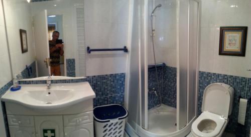 a bathroom with a sink and a shower and a toilet at Apartamento Limões in Carvoeiro