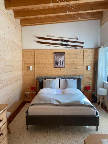 ein Schlafzimmer mit einem großen Bett und Holzwänden in der Unterkunft Apart Alps & Nature in See