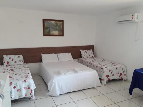um quarto de hotel com duas camas e uma mesa em Pousada CERTRI em Triunfo