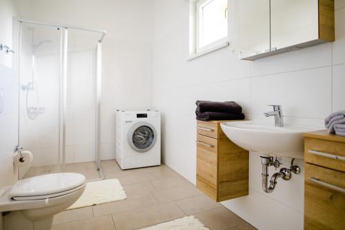 a bathroom with a sink and a washing machine at Ferienwohnung Modi in Gamlitz