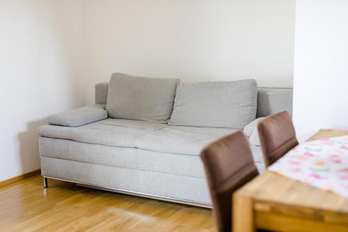 a gray couch in a living room with a table at Ferienwohnung Modi in Gamlitz