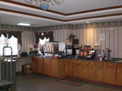 una cucina con mobili in legno e un piano di lavoro di Days Inn by Wyndham Butler a Butler