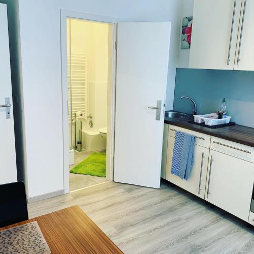 a kitchen with a door leading to a bathroom at Pension Belo Sono in Munich