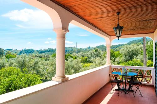 a porch with a table and chairs and a view at A Casa do Olival - Barragem Castelo do Bode-Tomar in Barreira Grande