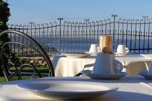 a table with white tables and chairs with a view of the ocean at Casaliva in Bardolino