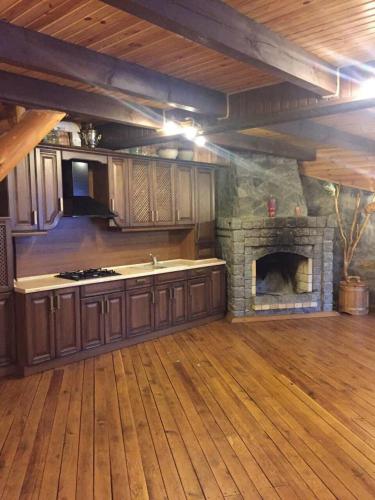 a kitchen with a stone fireplace in a room at Будинок для відпочинку в лісі in Berëzovka