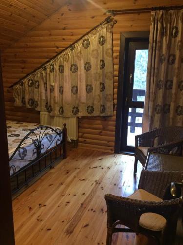 a bedroom with a bed and a window in a cabin at Дом для отдыха в лесу in Berëzovka