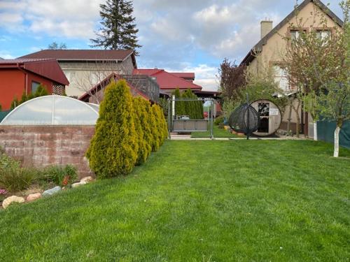 a yard with green grass and a house at Holiday Home V Kolte in Kolta