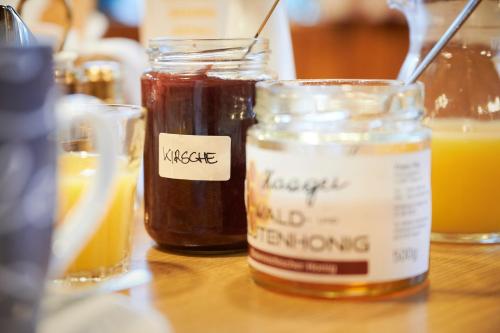 a table with three jars of honey and orange juice at Gasthof Mittendorfer in Haag am Hausruck