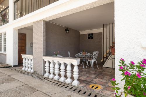 a patio with a white railing and a table at Janes' Serenity Guesthouse in Anse a La Mouche