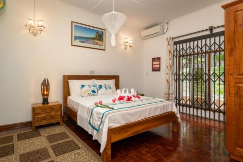 a bedroom with a bed with flowers on it at Janes' Serenity Guesthouse in Anse a La Mouche