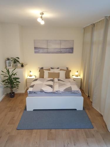 a bedroom with a white bed and two lamps at Ferienwohnung Einfeld in Neumünster