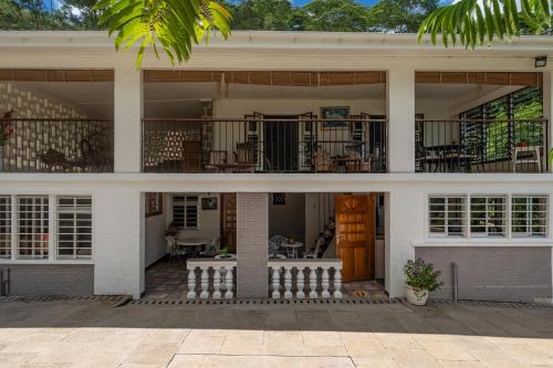 a house with a porch and a balcony at Janes' Serenity Guesthouse in Anse a La Mouche
