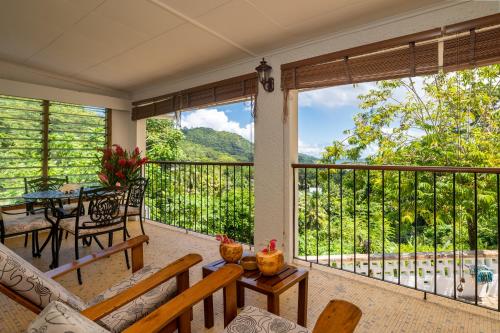 a screened in porch with a table and chairs at Janes' Serenity Guesthouse in Anse a La Mouche