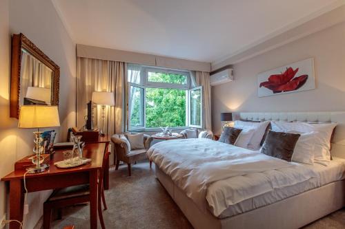 um quarto com uma cama, uma secretária e uma janela em Solitaire em Poděbrady