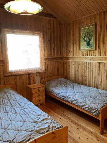 a bedroom with two beds and a window at Domek Green Dźwirzyno in Dźwirzyno